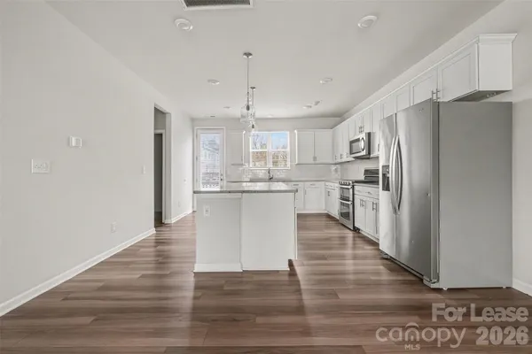 a kitchen with stainless steel appliances granite countertop white cabinets and window