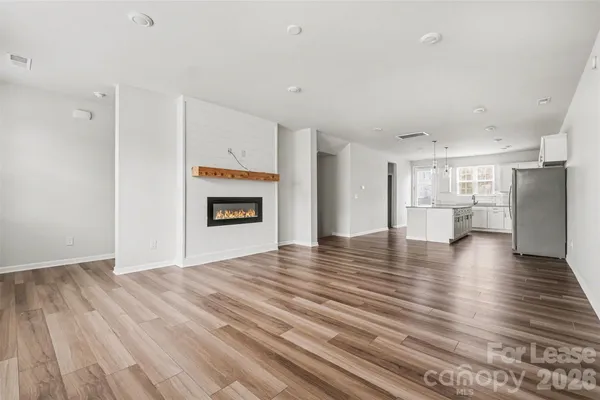 a view of empty room with wooden floor and window
