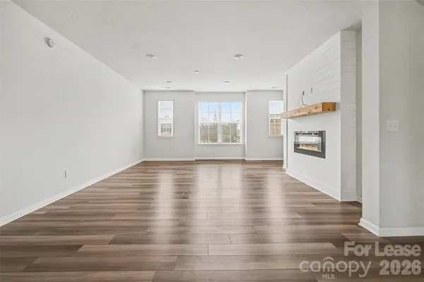 a kitchen with a refrigerator a sink and wooden floors