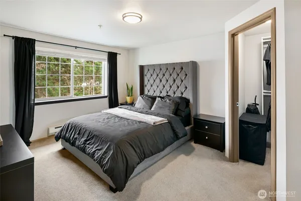 a bedroom with a bed and a large window