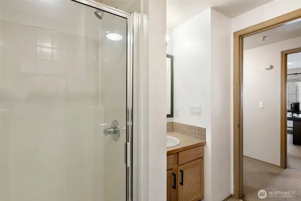 a bathroom with a granite countertop shower sink and mirror