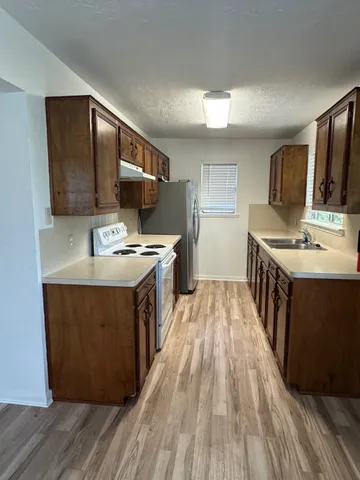 a kitchen with stainless steel appliances granite countertop a stove a sink and a microwave