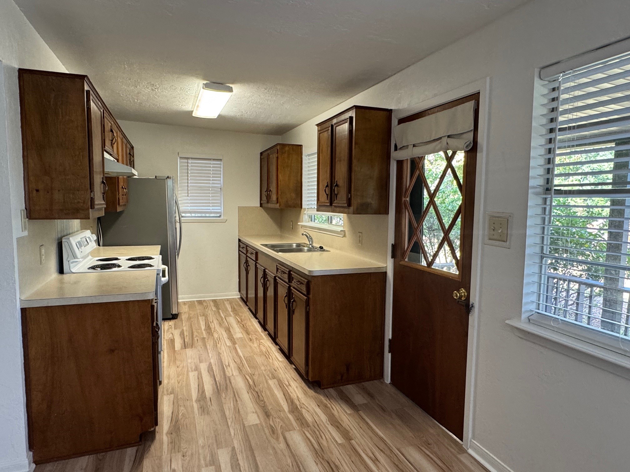 18121 Atkinson Lane Conroe, TX 77384 - Photo 15 of 29 a kitchen with stainless steel appliances granite countertop a refrigerator a sink dishwasher a stove and a dining table with wooden floor