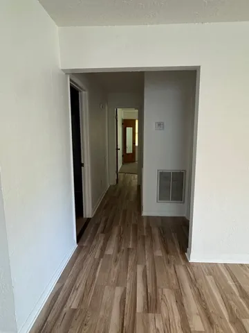 a view of a room with wooden floor