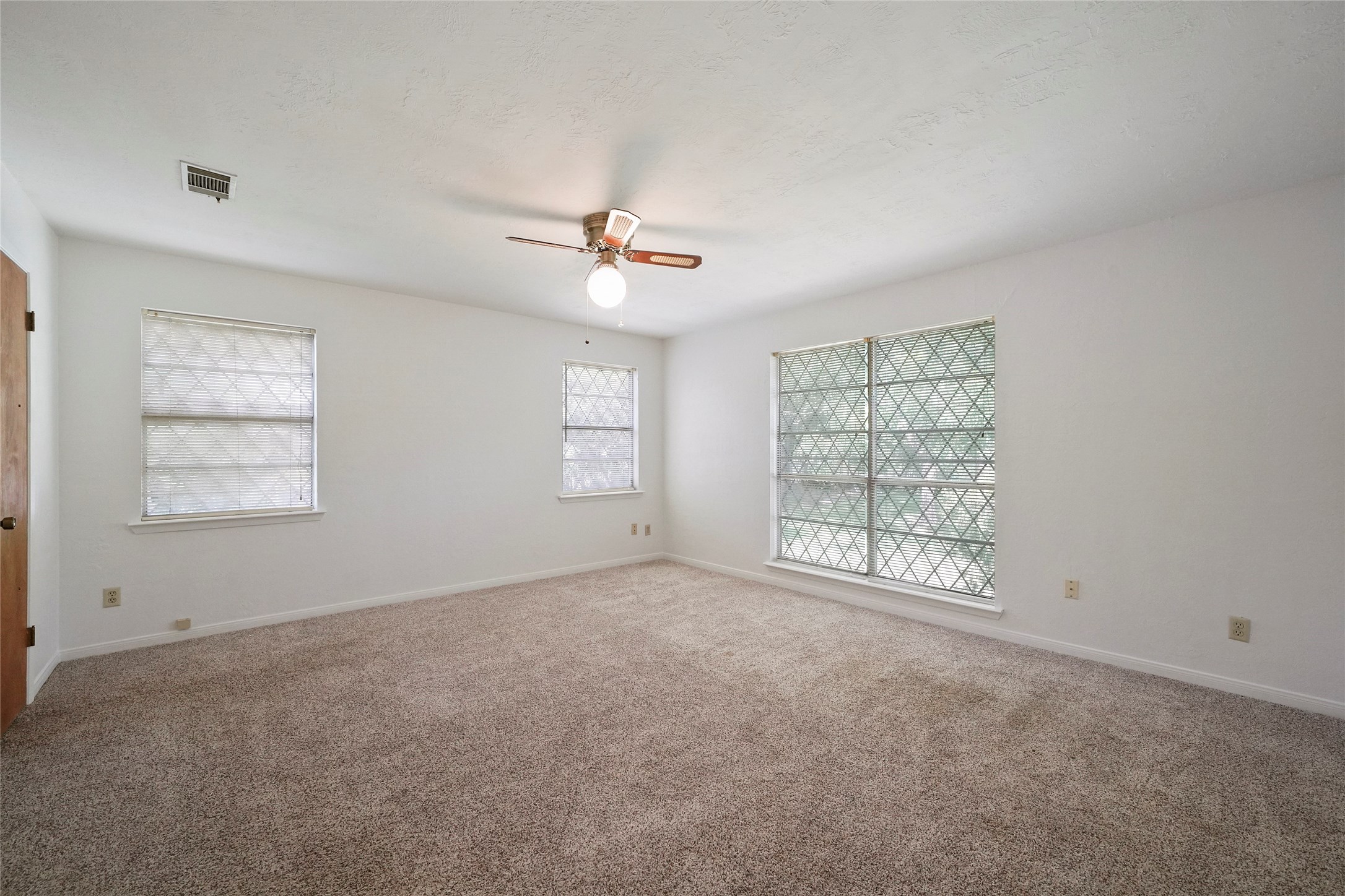 18121 Atkinson Lane Conroe, TX 77384 - Photo 20 of 29 an empty room with windows and fan