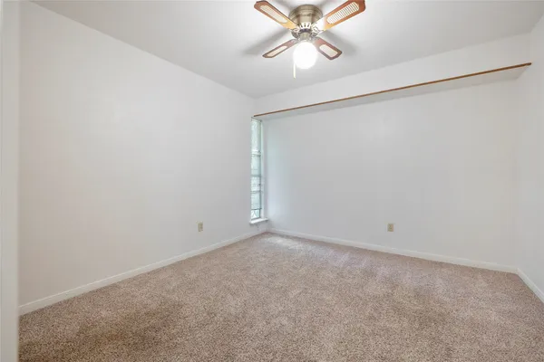 an empty room with chandelier fan