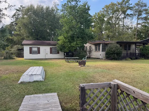 a front view of house with yard and trees in the background