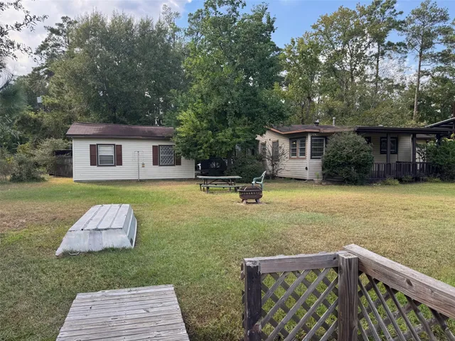 a front view of house with yard and trees in the background