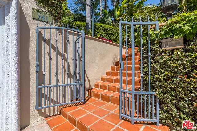 a view of a backyard with table and chairs potted plants and palm tree