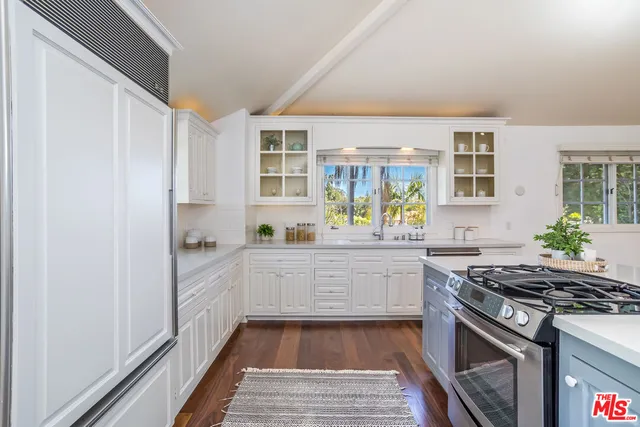 a view of a kitchen with kitchen island and stainless steel appliances