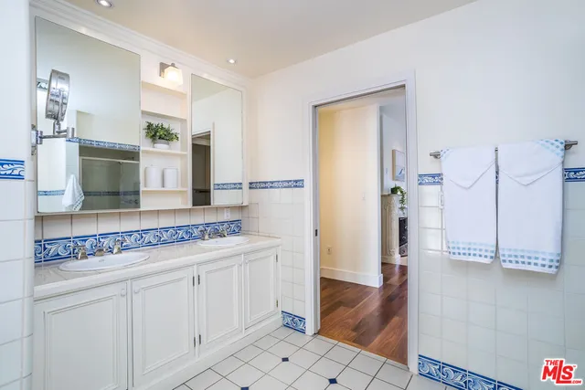 a bathroom with a granite countertop sink and a large mirror