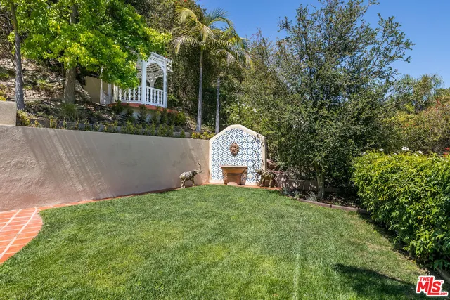 a view of a chair and table in backyard of the house