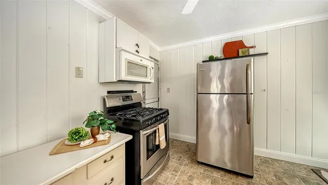 a kitchen with white cabinets and appliances