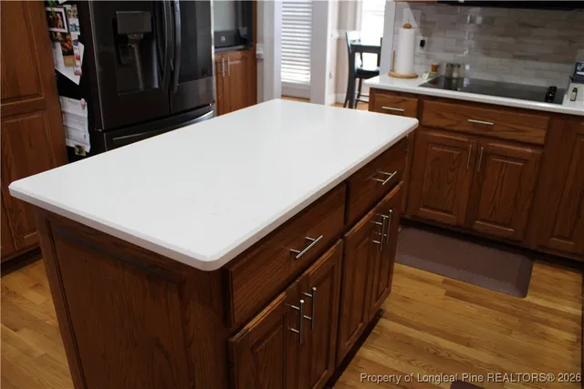 a kitchen with a sink dishwasher and wooden cabinets with a dining table