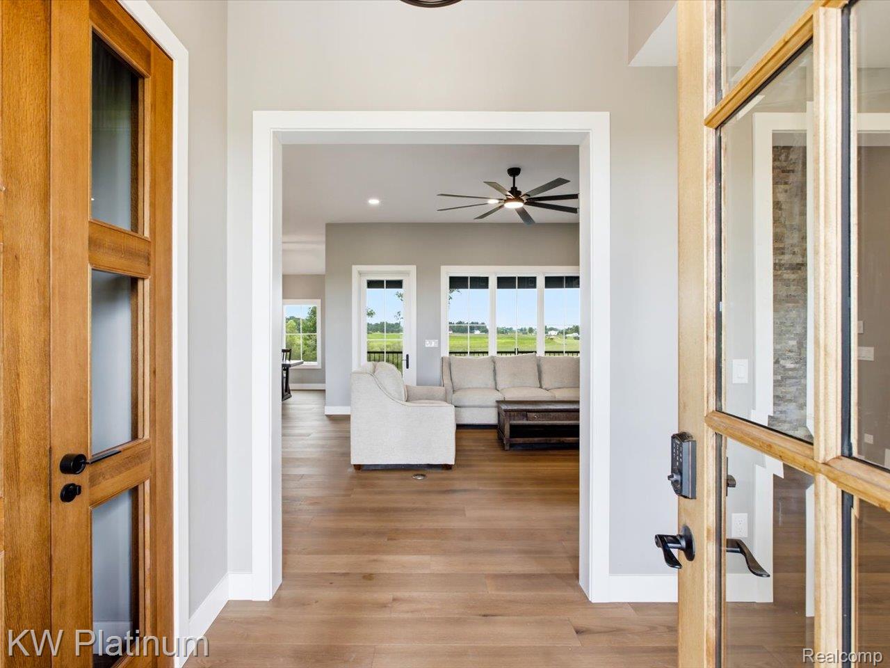 493 Wood Road Snover, MI 48472 - Photo 12 of 60 Entryway featuring wood-finish flooring, a wood-frame glass door with dark hardware, a wide doorway, and light gray walls