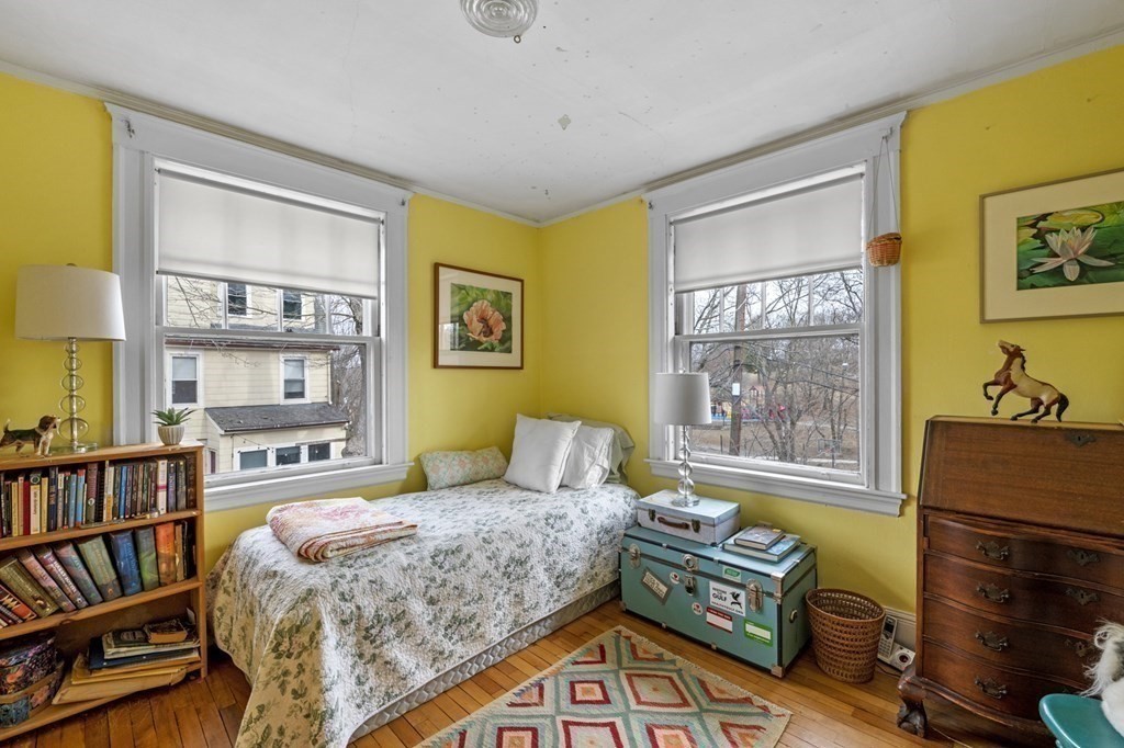 10 High Rock Way Boston, MA 02135 - Photo 19 of 26 a bedroom with a bed bookshelf and a window