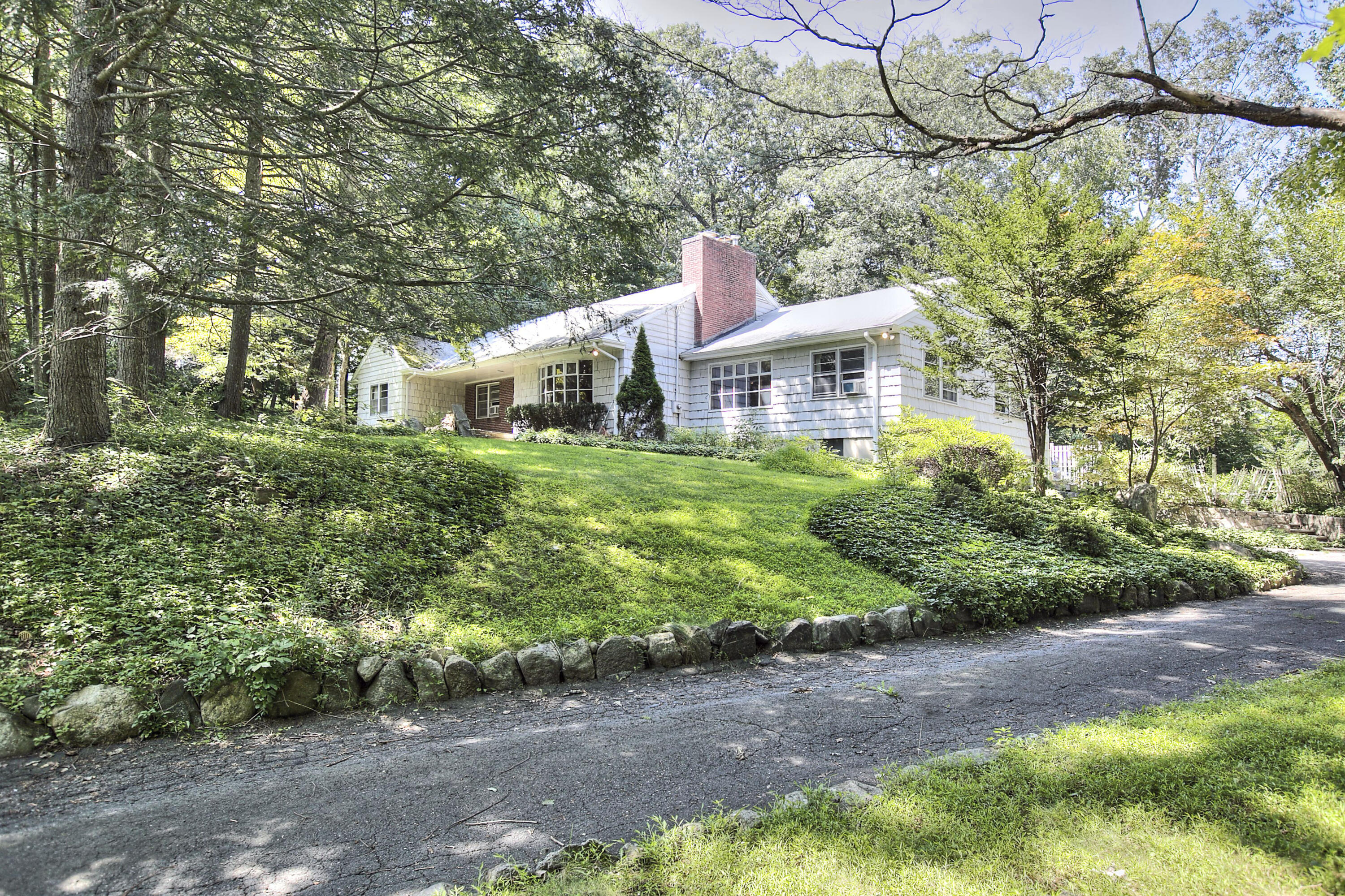 25 Hillcrest Road New Canaan, CT 06840 - Photo 19 of 19 a front view of a house with a yard and potted plants