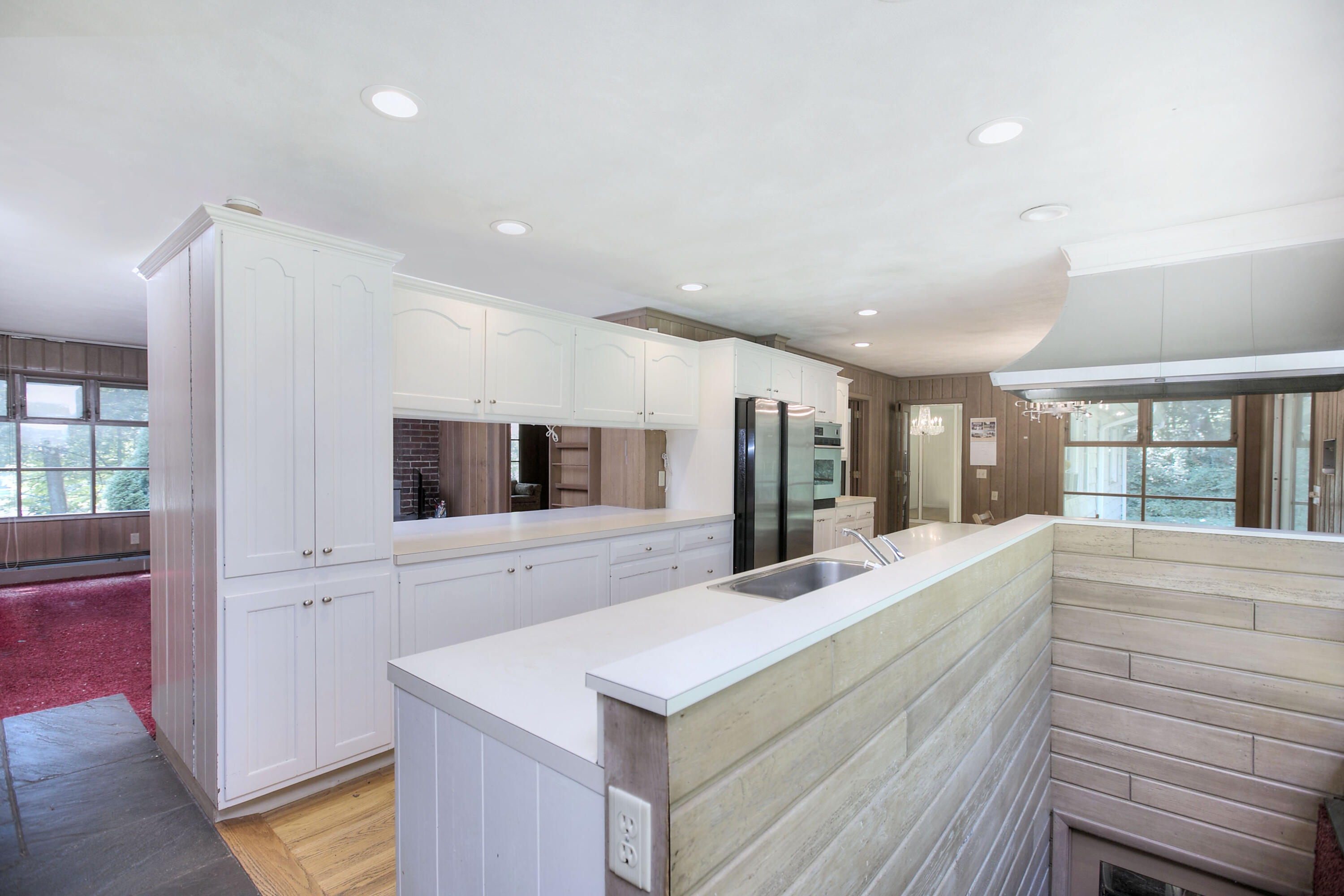 25 Hillcrest Road New Canaan, CT 06840 - Photo 4 of 19 a large white kitchen with kitchen island a stove and a large window