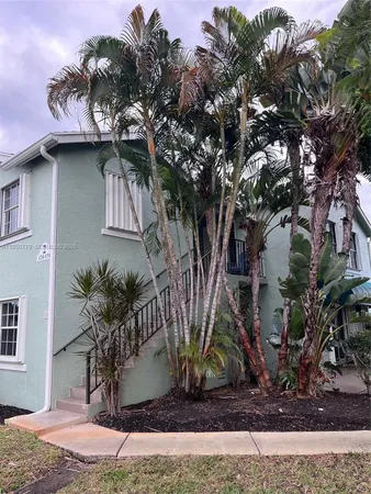 a front view of a house with a tree