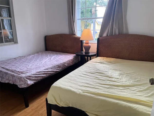 a bedroom with two beds and a large window