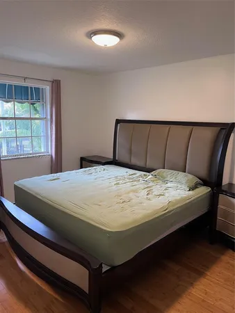 a bed sitting in a bedroom next to a window