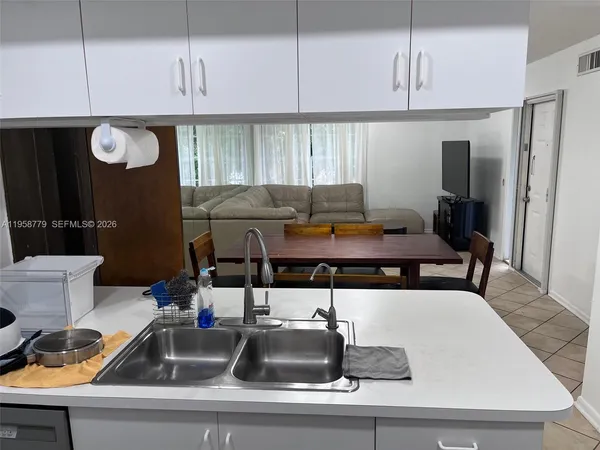 a kitchen with a sink a counter space and stainless steel appliances