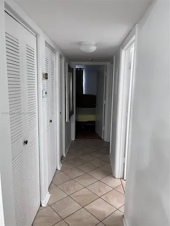 a view of a hallway with closet and bathroom
