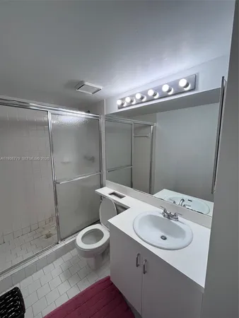 a bathroom with a sink toilet and shower