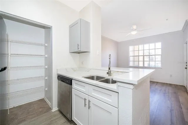 a kitchen with a sink cabinets and wooden floor