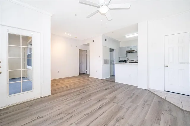 a view of a kitchen with wooden floor and a ceiling fan
