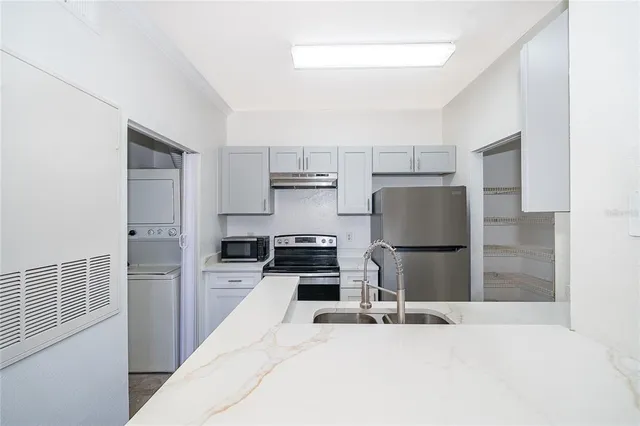 a kitchen with a refrigerator a stove and a sink