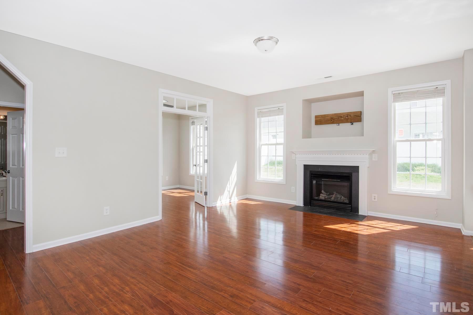 7814 Braefield Drive Raleigh, NC 27616 - Photo 14 of 29 a view of an empty room with wooden floor and a window