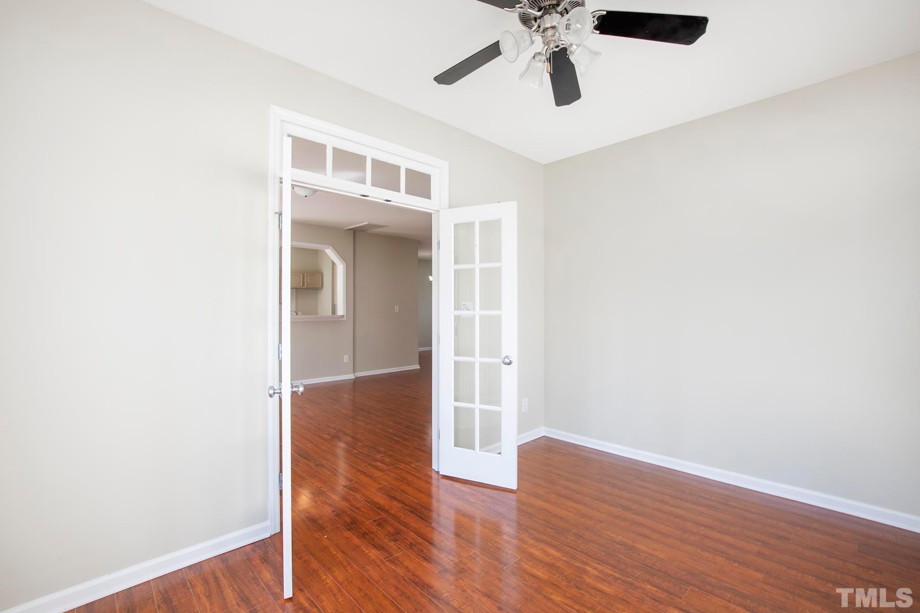7814 Braefield Drive Raleigh, NC 27616 - Photo 15 of 29 an empty room with wooden floor cabinet and windows