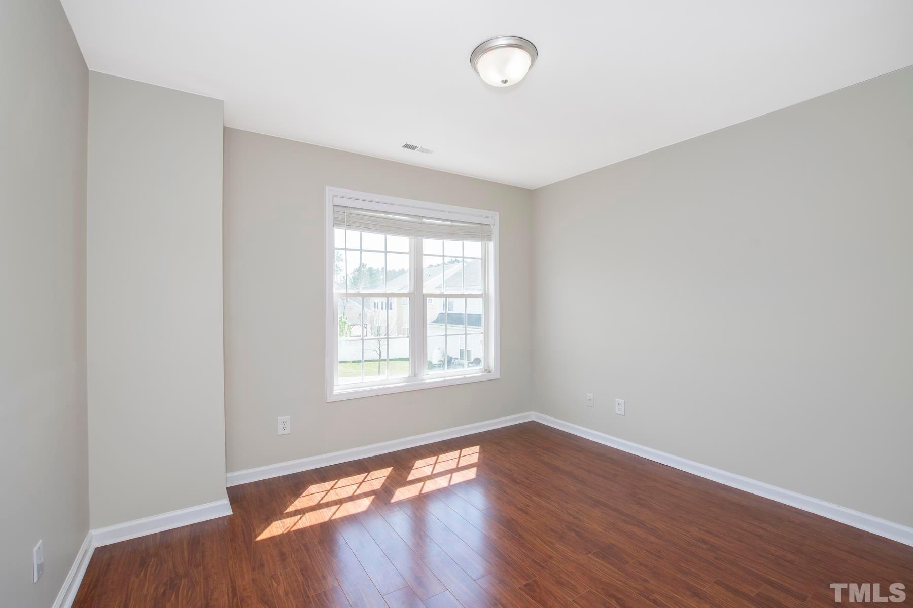 7814 Braefield Drive Raleigh, NC 27616 - Photo 17 of 29 an empty room with wooden floor and windows