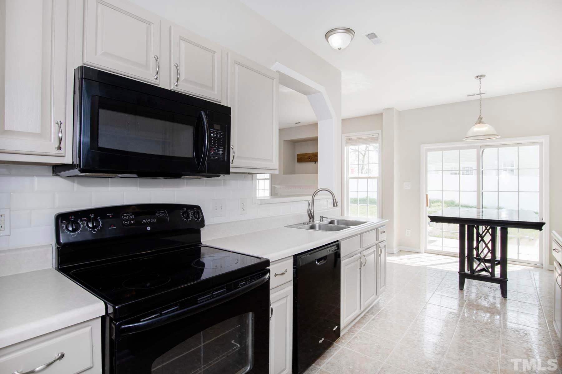 7814 Braefield Drive Raleigh, NC 27616 - Photo 8 of 29 a kitchen with stainless steel appliances a stove sink microwave and cabinets