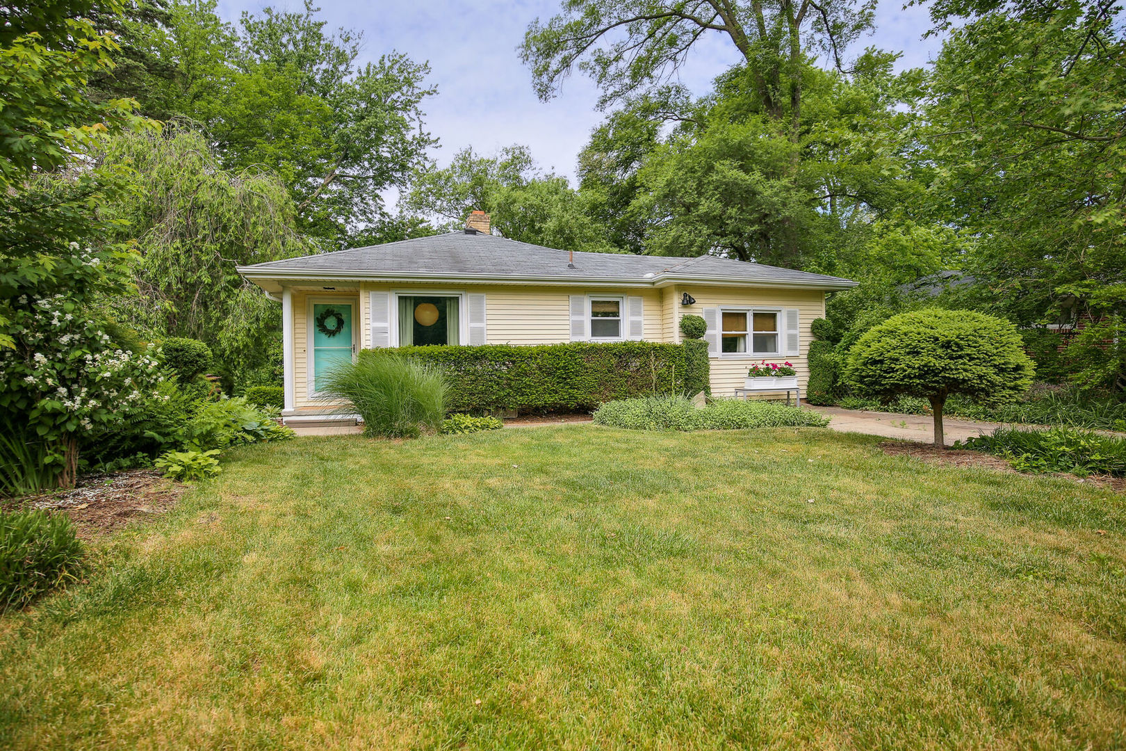 a front view of a house with a garden