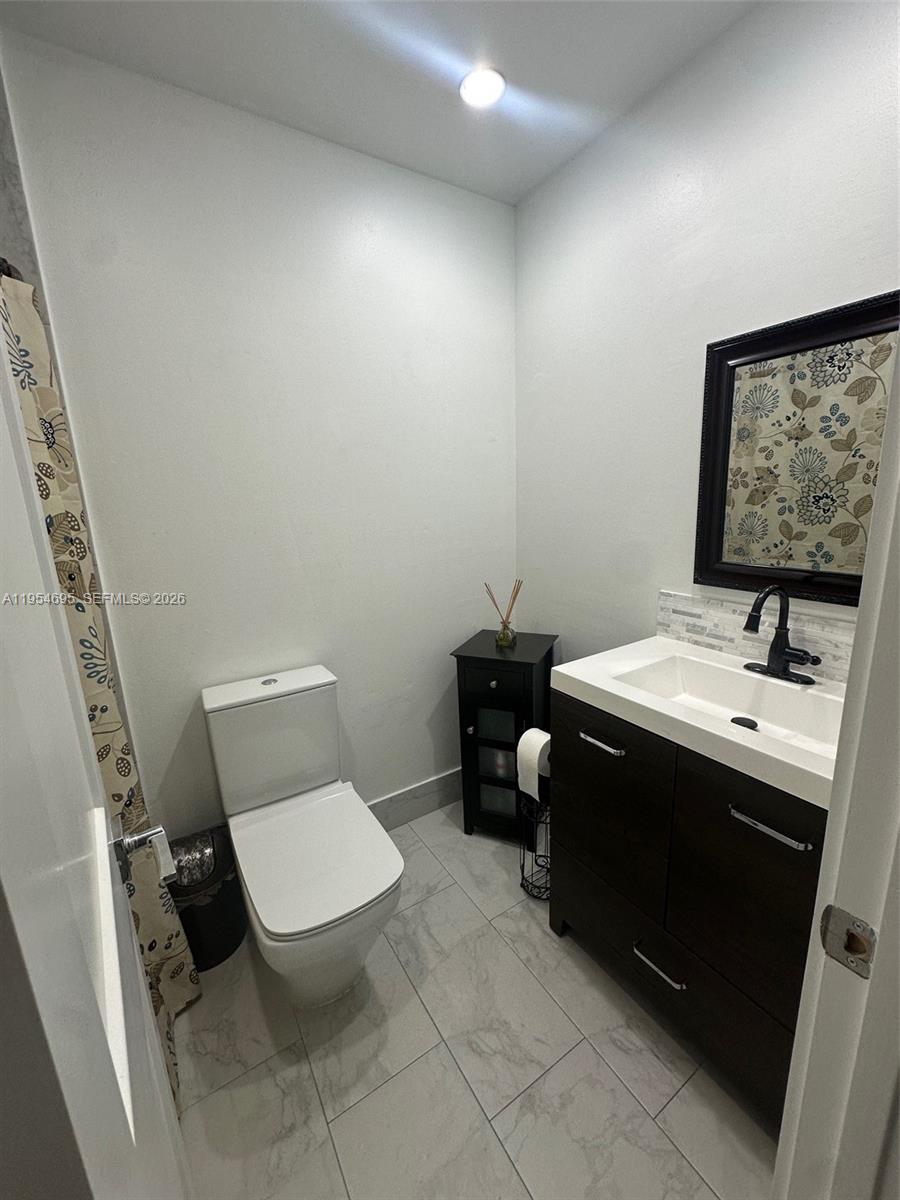 13671 Southwest 62nd Street, Unit 2011 Miami, FL 33183 - Photo 11 of 24 a bathroom with a toilet sink and mirror