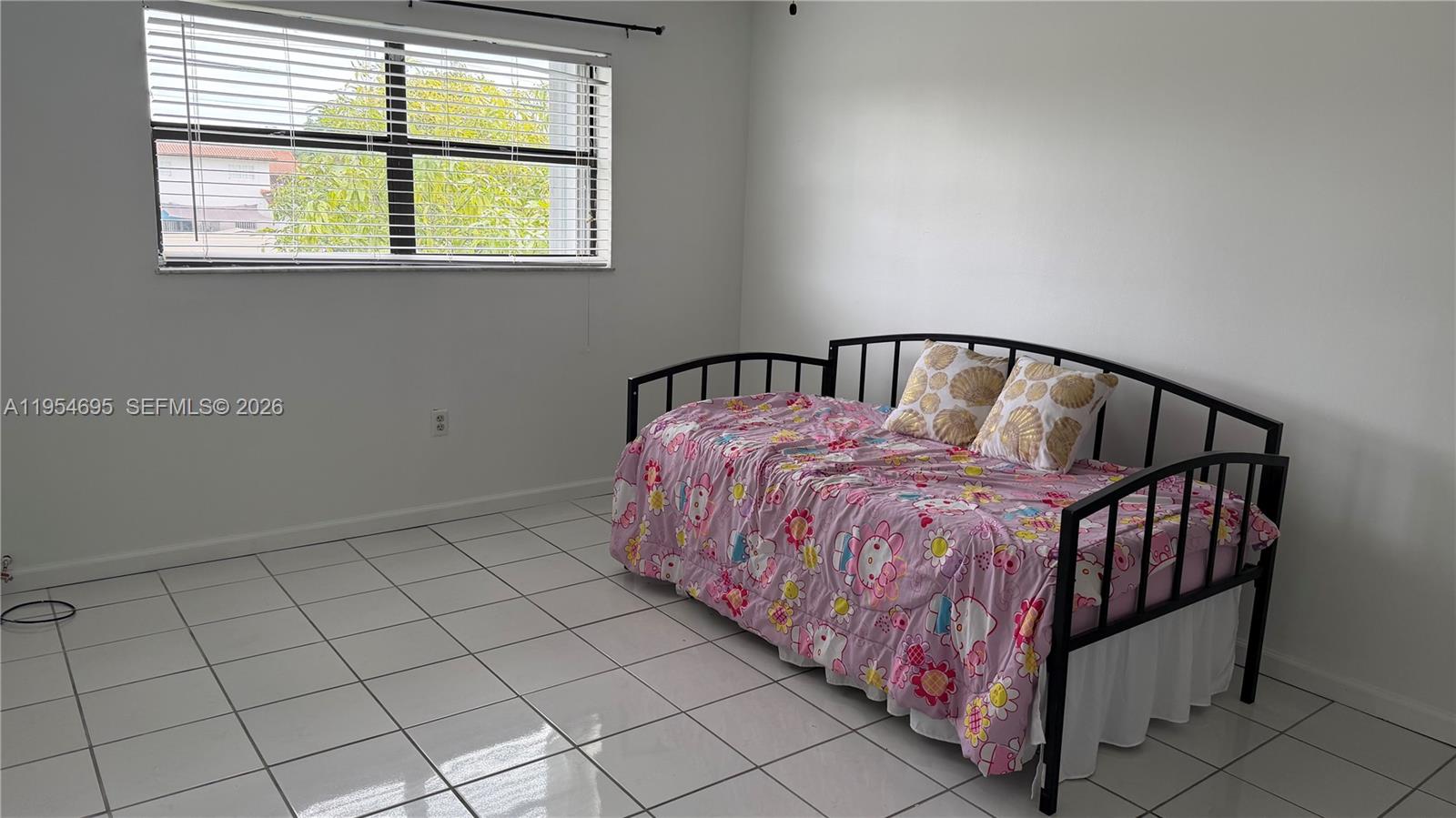 13671 Southwest 62nd Street, Unit 2011 Miami, FL 33183 - Photo 11 of 20 a bed sitting in a bedroom next to a window