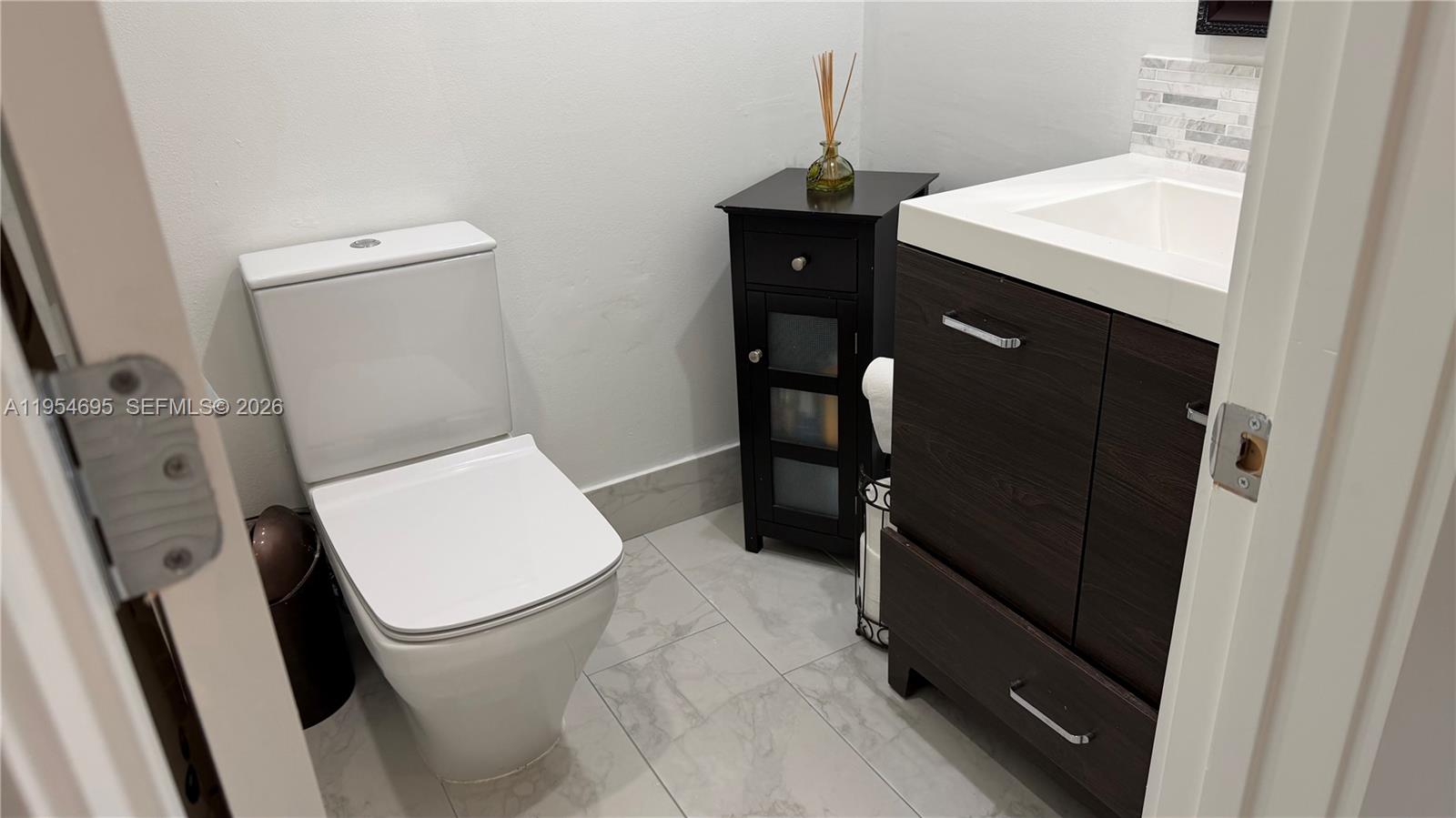 13671 Southwest 62nd Street, Unit 2011 Miami, FL 33183 - Photo 14 of 20 a bathroom with a sink a toilet and vanity