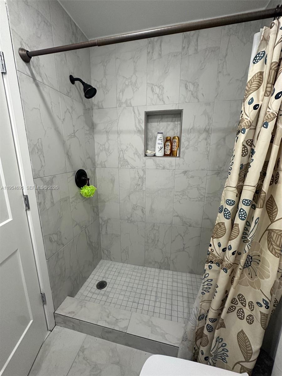 13671 Southwest 62nd Street, Unit 2011 Miami, FL 33183 - Photo 14 of 24 a bathroom with a shower and a toilet next to a window