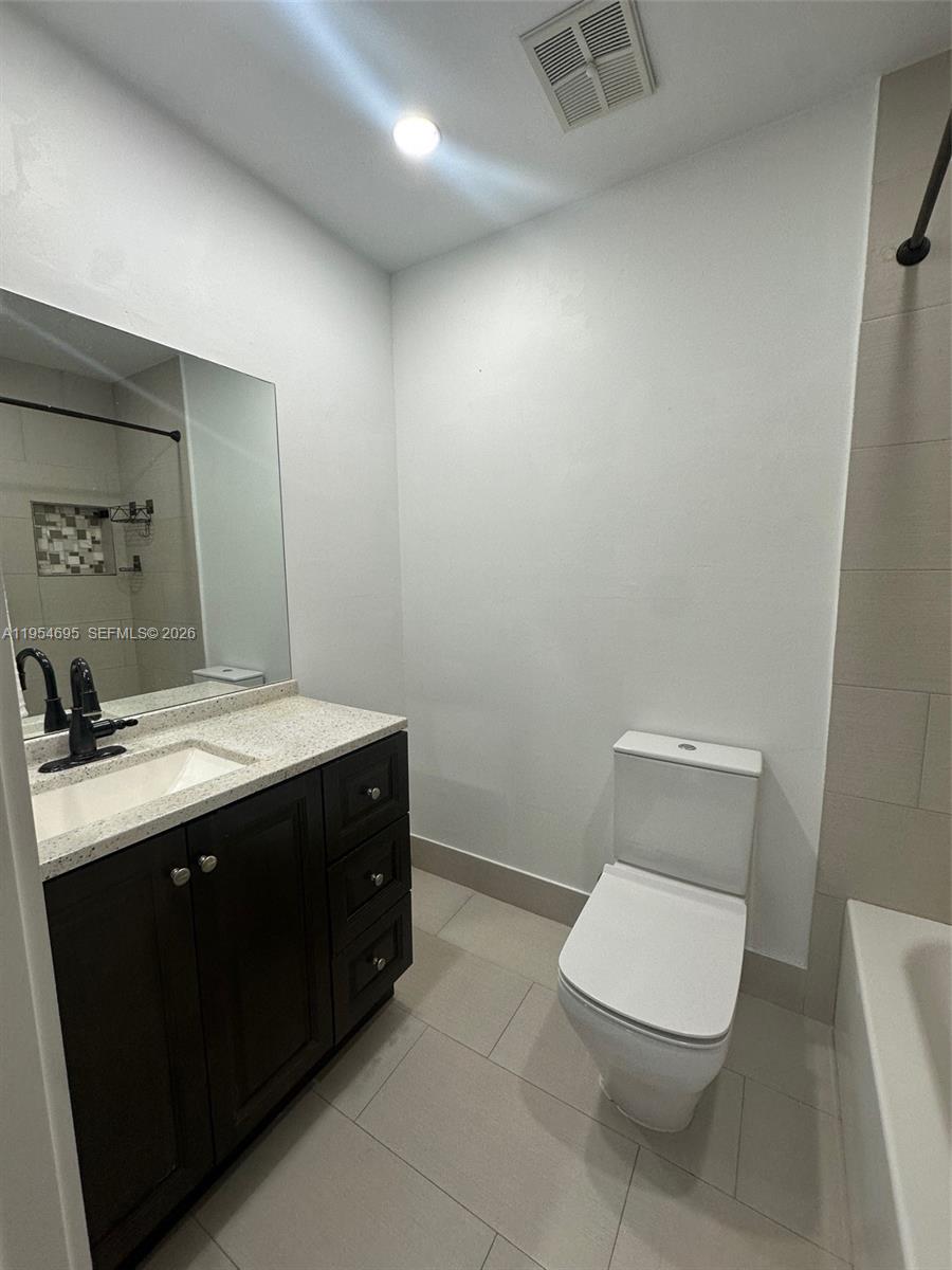 13671 Southwest 62nd Street, Unit 2011 Miami, FL 33183 - Photo 17 of 24 a bathroom with a toilet sink and mirror