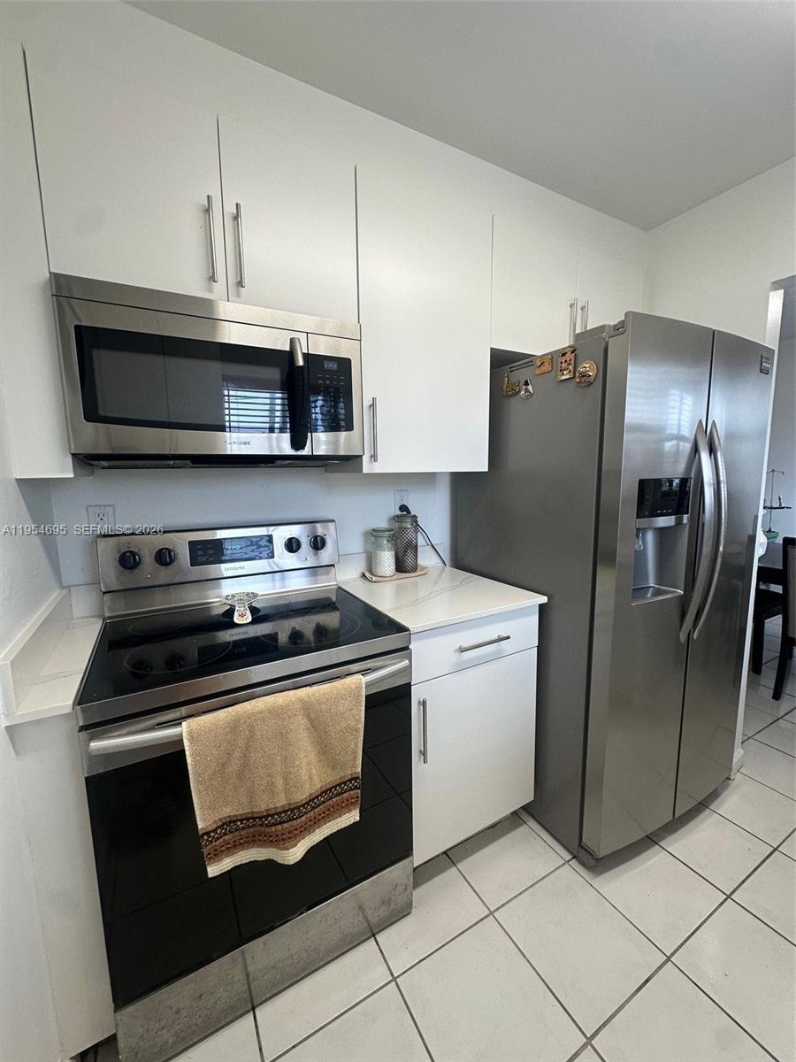 13671 Southwest 62nd Street, Unit 2011 Miami, FL 33183 - Photo 3 of 24 a kitchen with stainless steel appliances granite countertop a stove a refrigerator and a microwave