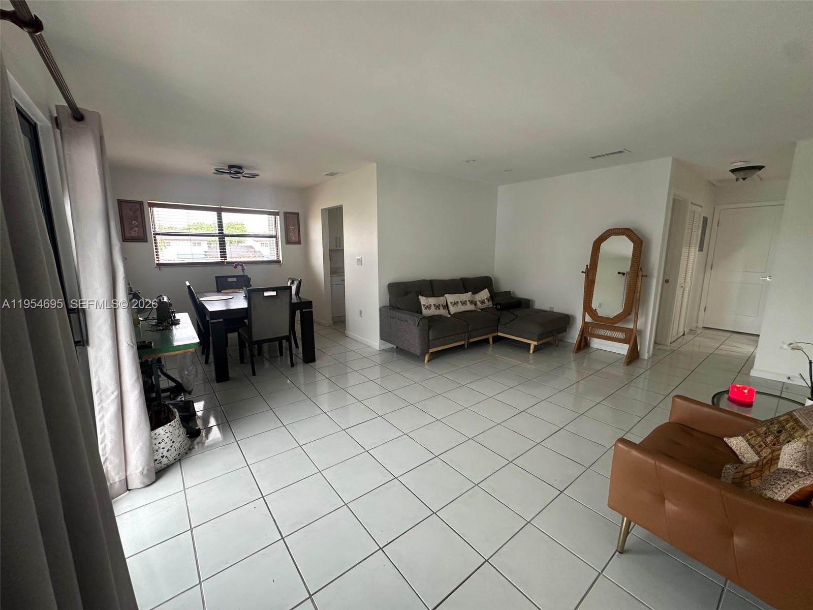 13671 Southwest 62nd Street, Unit 2011 Miami, FL 33183 - Photo 6 of 24 a living room with furniture a dining table and a rug