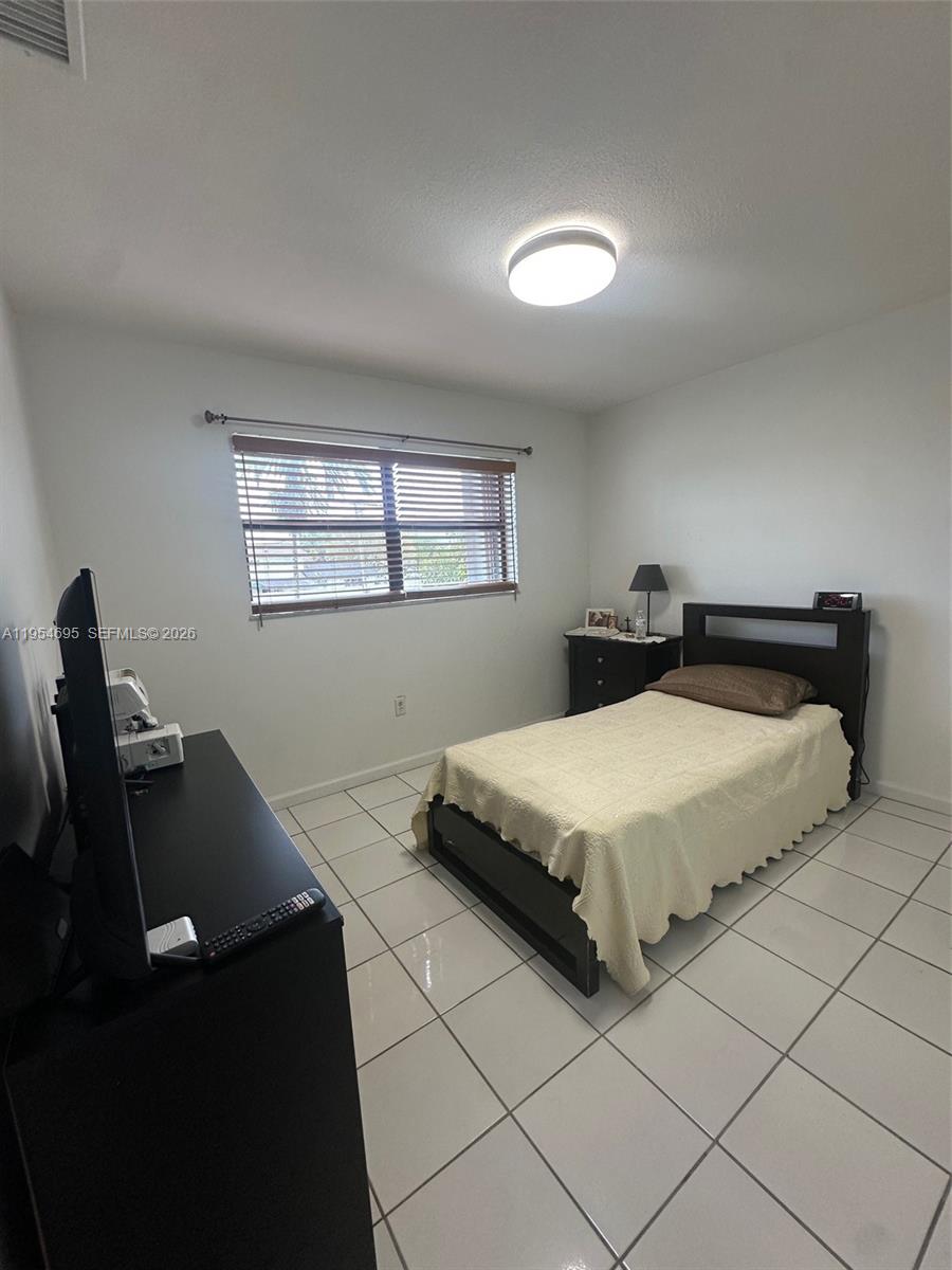 13671 Southwest 62nd Street, Unit 2011 Miami, FL 33183 - Photo 10 of 24 a bedroom with a bed and window