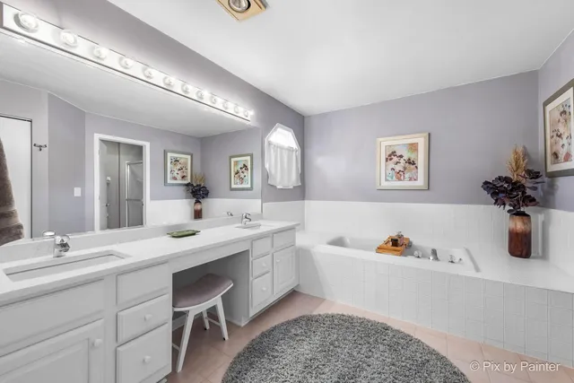 a spacious bathroom with a tub sink and mirror