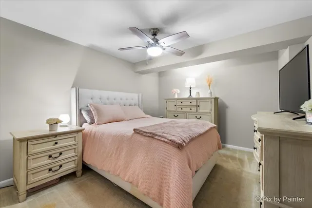 a bedroom with a bed and a flat tv screen on dresser