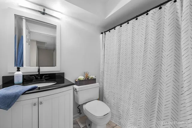 a bathroom with a toilet a sink and mirror