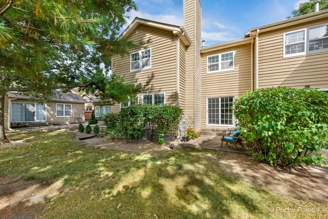 a view of a house with backyard and sitting area