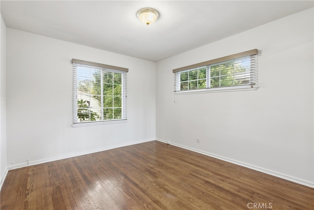 16753 Magnolia Boulevard Encino, CA 91436 - Photo 12 of 30 an empty room with wooden floor and windows