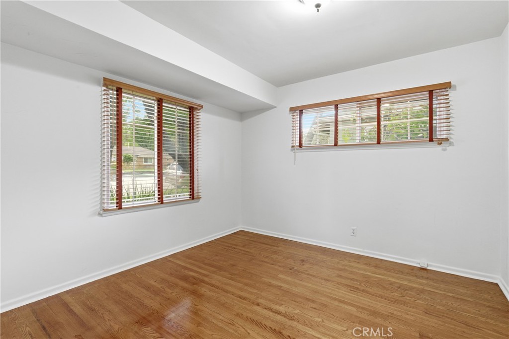 16753 Magnolia Boulevard Encino, CA 91436 - Photo 14 of 30 an empty room with wooden floor and windows